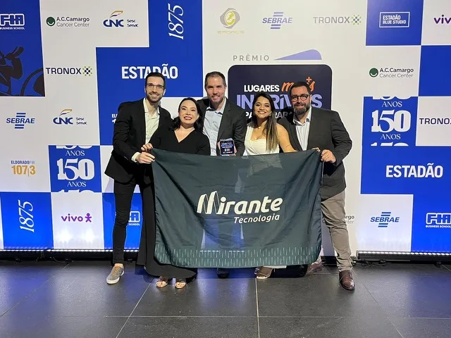Time da Mirante com a bandeira da empresa em premiação